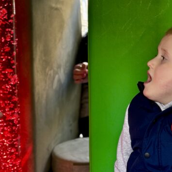 young boy excitedly watched red bubbles rise