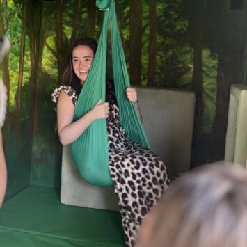 adult swings gently whilst smiling.
